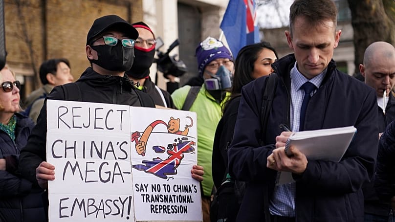 Gösterciler, Londra'da yeni Çin büyükelçiliğinin açılmasına karşı düzenlenen bir protestoya katılırken ellerinde pankartlar ve bayraklar tutuyor, 17 Ocak 2026.